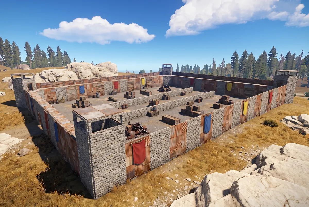 A purpose-built Rust arena walled in grey stone and sheet metal, with team banners and cover inside.